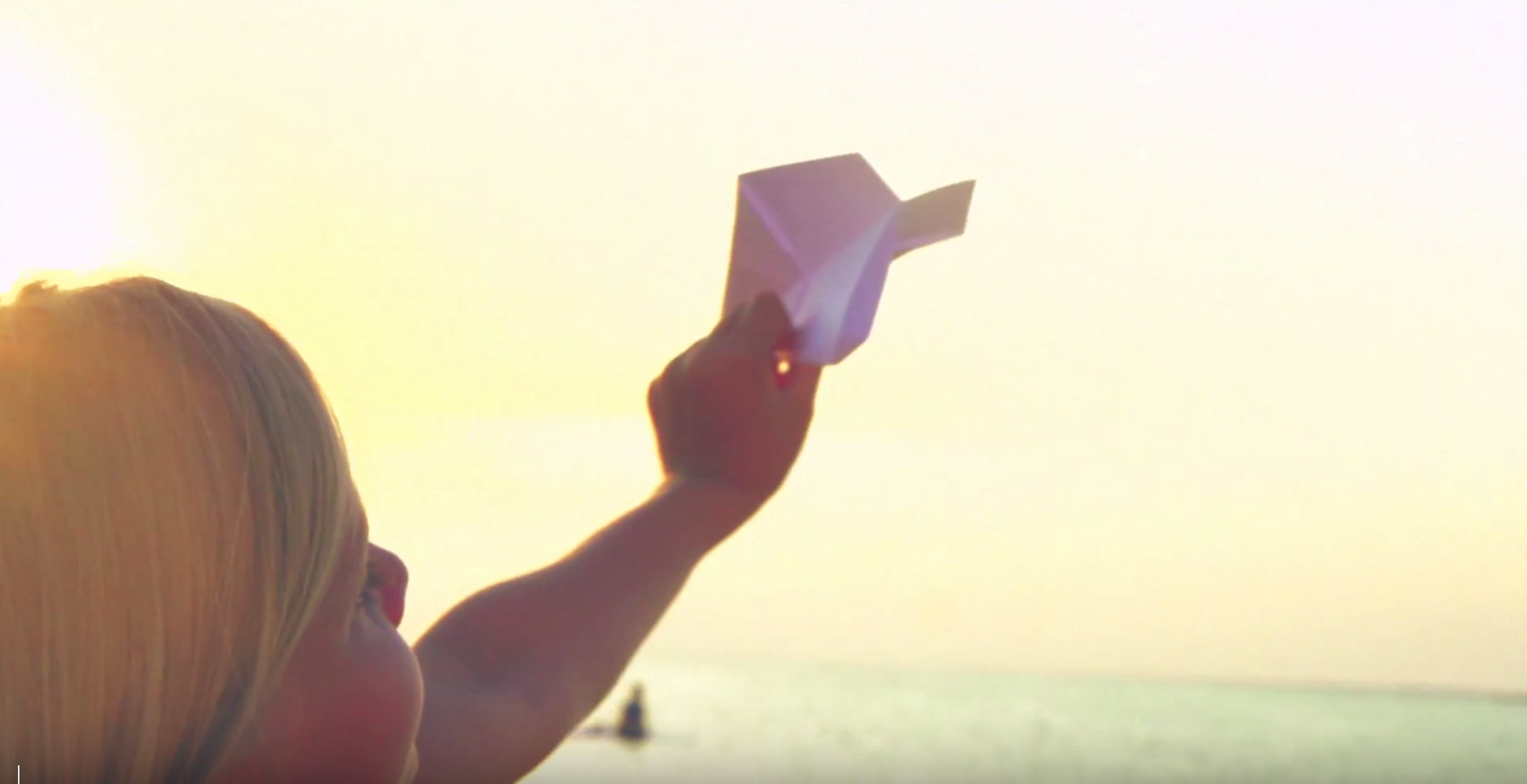 Girl flying a paper airplane