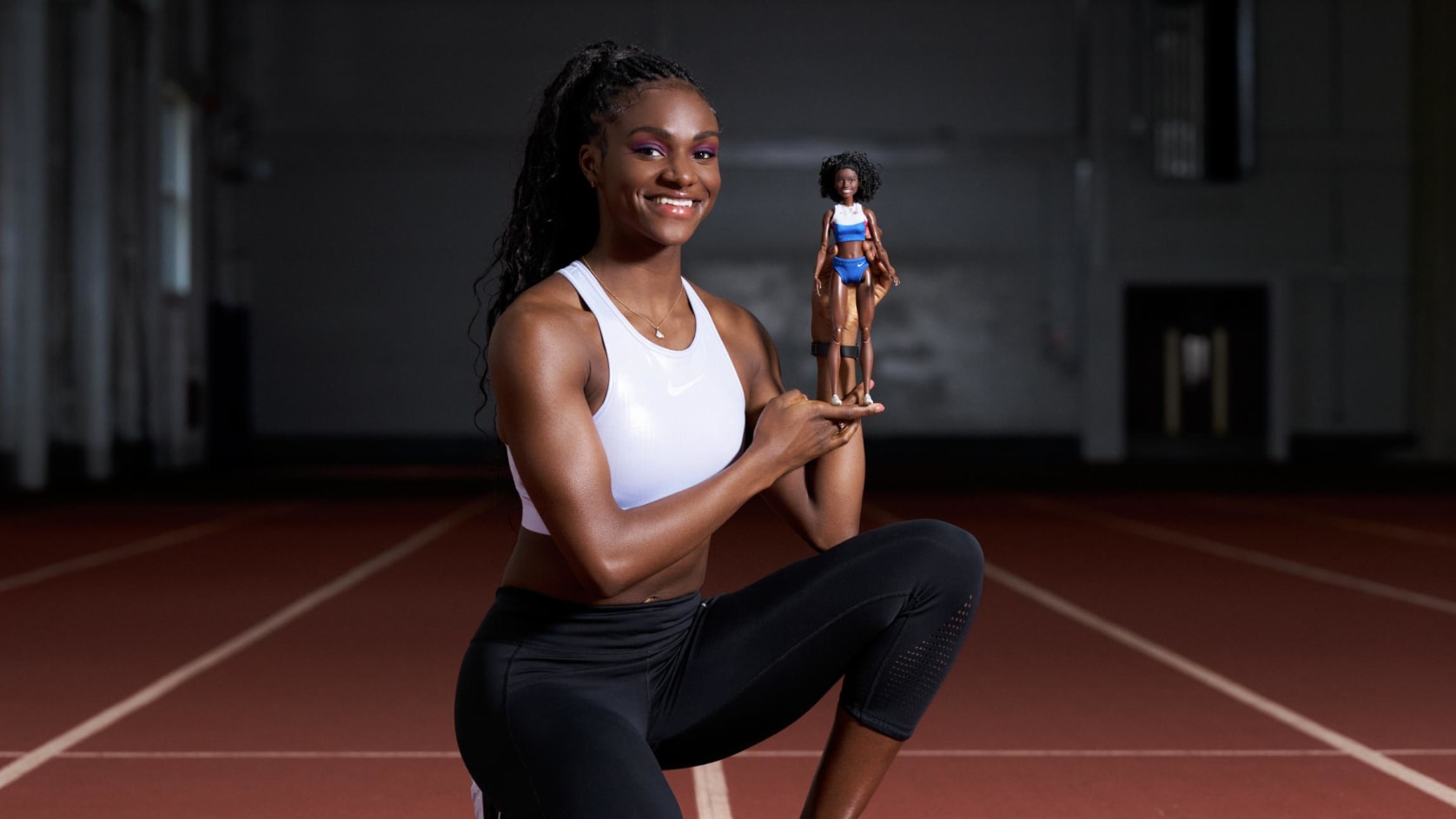 Dina Asher-Smith on the track holding her Barbie